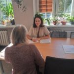 Konsultacje psychologiczne - psycholog przy biurku i osoba dorosła na przeciw specjalisty.